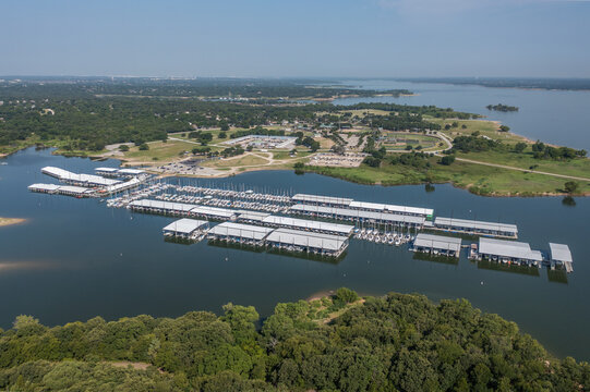 Aerial Drone View of Large White Boat Dock and Pier On Blue Lake Near Grassy Park in Grapevine, Texas