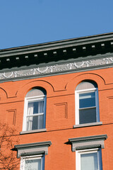 Obraz premium Red brick building with arches and decorative details in urban area during bright daylight