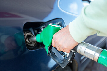 Man filling up gasoline fuel in car holding pump
