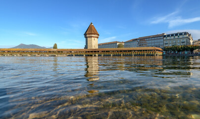 Obraz premium Chapel Bridge and Water Tower reflected in the Reuss River, Lucerne, Switzerland