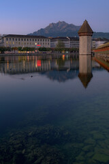 Obraz premium Lucerne cityscape with Chapel Bridge tower and Pilatus mountain at dusk