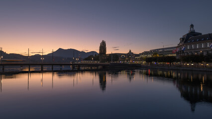 Fototapeta premium Lucerne cityscape at dusk with mountains and river reflections, Switzerland