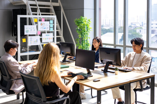 Modern office with team of business people working together using computer in online coding and investment for programming and coding service