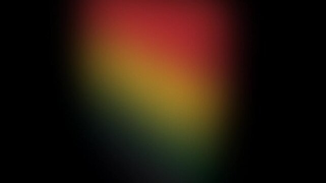 Subtle red, yellow, green color gradient background slowly transitioning onto a black backdrop with textured grain. Black history month theme concept.