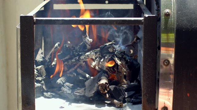 Charcoal catching fire, smoke in a windy day - Slowmotion - for Argentine barbecue asado