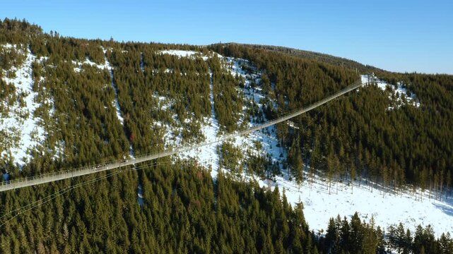 Sky Bridge 721, the longest suspension footbridge between two hills, stretching over a forest landscape in winter in Dolni Morava, Czech Republic.