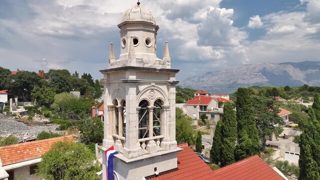 Drone footage of the Church of the Annunciation of the Blessed Virgin Mary with bell tower and Croatian flag in Novo Selo, Brac Island.