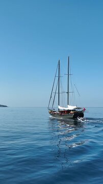 Elegant wooden gulet sailing on calm blue sea under clear sky
