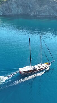 Aerial view of a traditional gulet sailing on crystal clear blue Mediterranean sea
