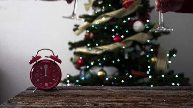 Man and woman clinking glasses of champagne celebrating new year's eve with a christmas tree