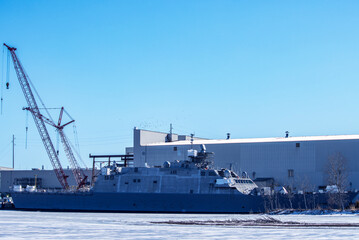 A naval warship in an icy harbor with blue sky © Brian