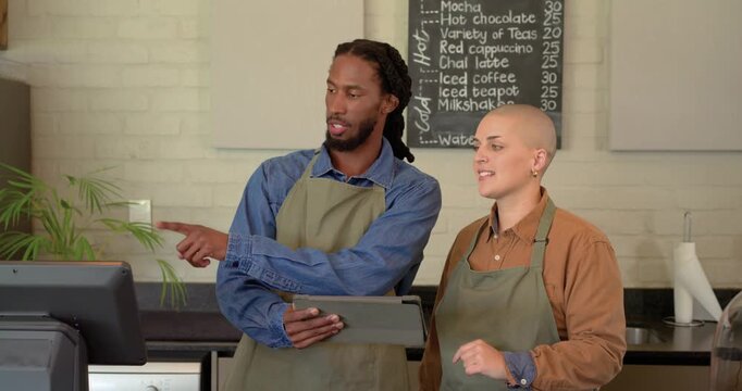After seeing menu update on tablet, diverse coworkers discussing register layout at coffee counter