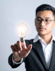 Young Businessman with Glowing Light Bulb Symbolizing Innovation and Bright Ideas.