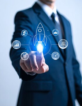 Businessman touching a glowing rocket icon surrounded by other business and technology symbols, representing startup, innovation, and digital transformation.