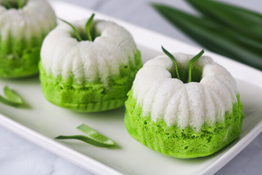 Closeup beautiful presentation of Kue Putu Ayu, the classic Indonesian steamed pandan cake. These soft, fluffy treats are topped with grated coconut.