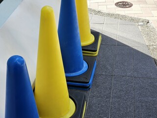 Blue and Yellow Traffic Cones on a Sidewalk in Tokyo.