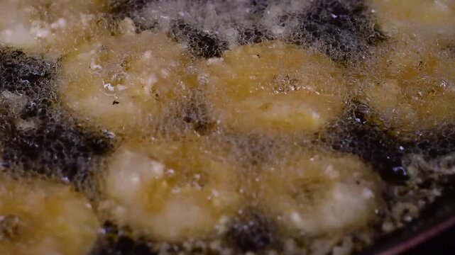Golden Banana Slices Sizzling in Hot Oil with Crispy Sweet Treat,Banana fritter,The banana and pineapple  fritters are frying in a hot pan