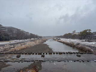 雪の舞う冬の鴨川