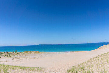 A beach with a blue ocean and a clear sky