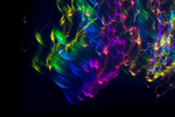 Fototapeta premium Abstract bright pink light streaks and glowing particles on a black background, ideal for futuristic, energetic, or festive designs