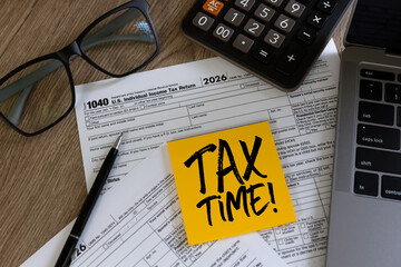 Tax time reminder concept paperwork, calculator and TAX TIME note , representing tax filing preparation, accounting services, audit readiness and financial documentation review.