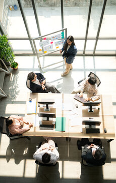 Top view of group business leader presenting information to a team during a meeting