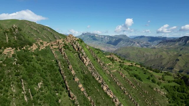 Drone aerial view of the mountain village of Gamsutl in Dagestan at sunrise with soft morning light and dramatic scenery.