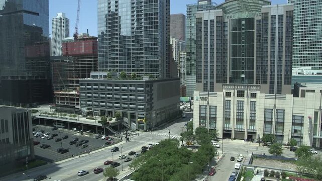 Chicago downtown streets and modern high-rise buildings near Aon Center, with traffic and construction cranes, daytime urban cityscape in the Loop.