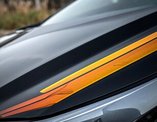 Fototapeta premium Close-up of a car hood with a black stripe and orange accents