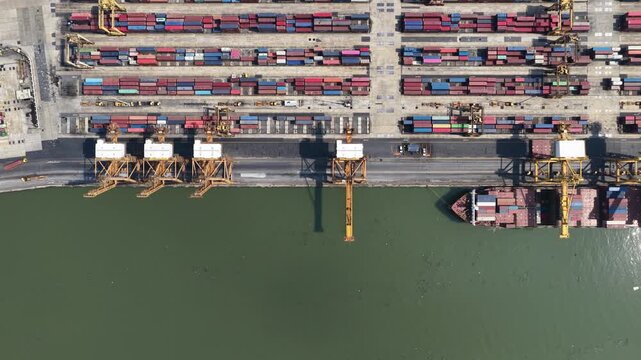 Aerial view of container ship departing from port terminal
