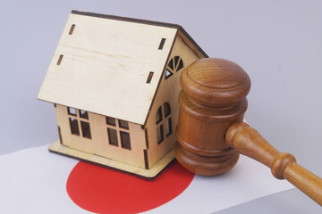 Judge gavel and house model on flag of Japan. Real estate, laws and court in Japan.	