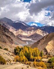 Mountain valley vista with autumn foliage, winding river, and dramatic sky