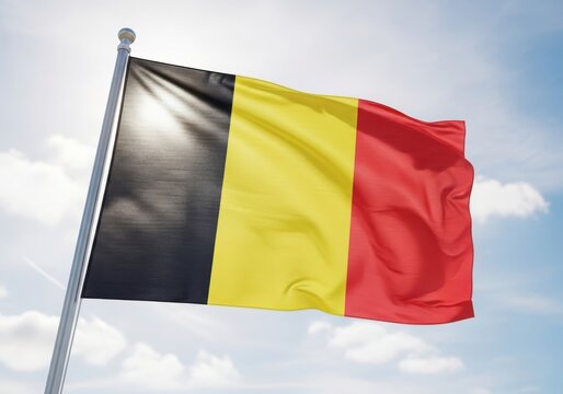 The belgian flag waving in the wind under a clear blue sky with white clouds