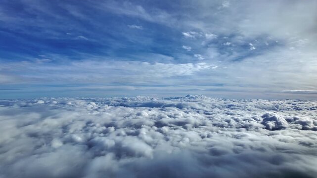 Pilot POV in a serene flight between layers of ethereal stratus clouds in a blue sky flying toward an infinite horizon.