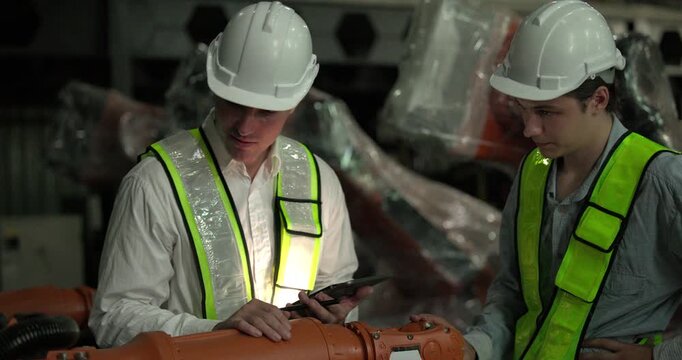Engineering supervisor mentors trainee in robotics environment, emphasizing the importance of leadership, communication, and continuous education in managing complex machinery and technical processes
