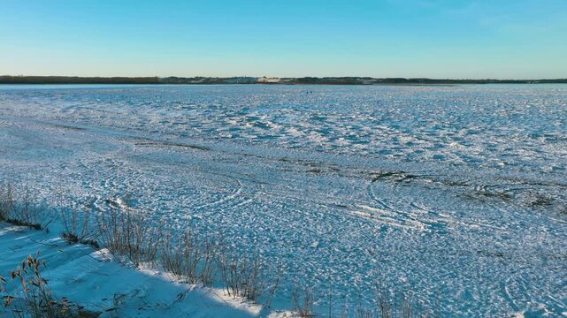 A wide aerial shot capturing the vast frozen landscape of the Baltic Sea in Rewa, Poland. Ideal for winter travel, climate change, and arctic environment concepts.