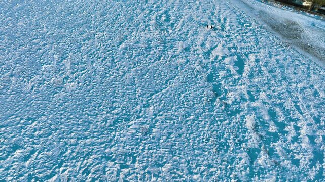 High angle drone shot revealing a vast frozen sea surface and coastal village in Rewa, Poland. Perfect for winter travel, climate change, and Baltic sea documentaries.