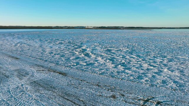 Stunning drone footage capturing the vast expanse of the frozen Baltic Sea coast in Rewa, Poland. Ideal for travel documentaries and winter climate content.
