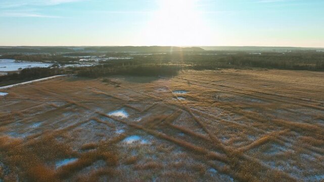Stunning aerial shot of a golden sunset over frozen marshlands and reed fields in Rewa, Poland. Perfect for nature documentaries, winter travel, and environmental storytelling.