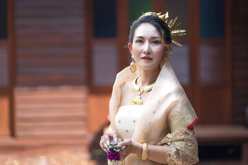 Naklejka premium Beautiful Asian Woman in Luxurious Gold Thai Traditional