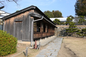 城跡に佇む伝統的な木造平屋建築と石畳の道
