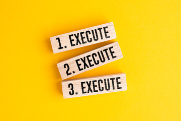 Naklejka premium Wooden block dengan tiga pengulangan kata execute, execute, dan execute. konsep yang konsisten