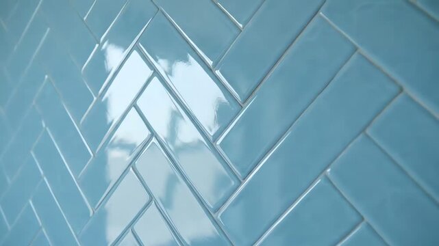 Close-up perspective of a modern, shiny, and vibrant blue glazed herringbone tile pattern, expertly laid on a wall, showcasing luxurious, stylish interior design aesthetic.