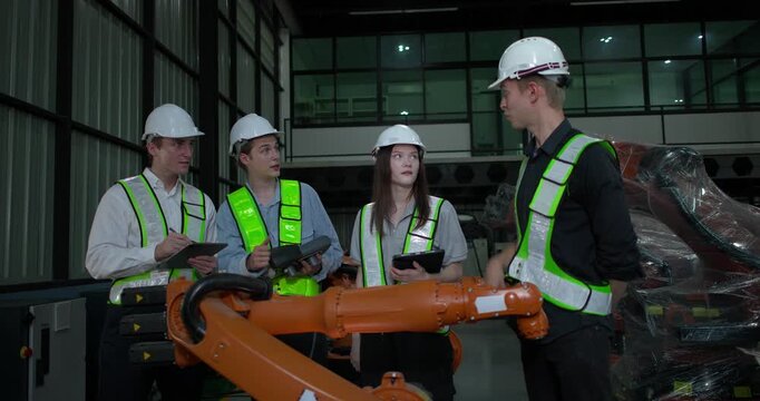 Engineering supervisor mentors trainee in robotics environment, emphasizing the importance of leadership, communication, and continuous education in managing complex machinery and technical processes
