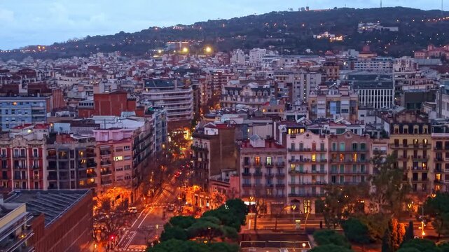 Nighttime aeria&ograve;l of La Nova Esquerra de l&rsquo;Eixample in Barcelona, featuring illuminated Carrer de Tarragona and Avinguda de Roma, and the Montju&iuml;c hillside glowing in the background at dusk.