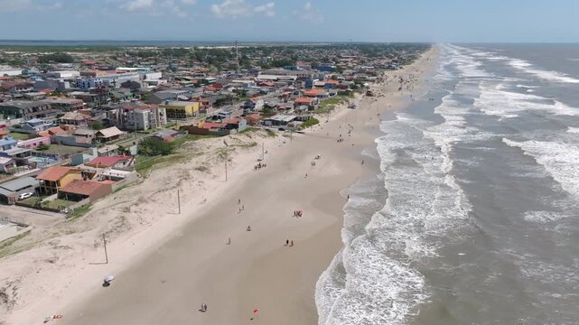 Sliding drone partial orbit along Balneario Pinhal beach and city coastline. Captured in D-Log with 10-bit color using a Hasselblad sensor.