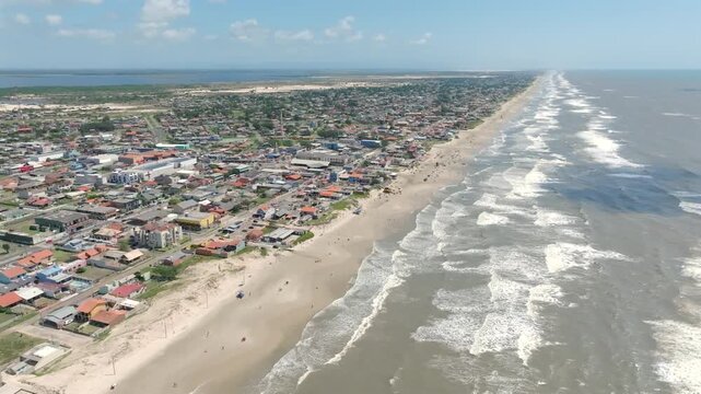 Diagonal pullback drone over Balneario Pinhal beach city. Captured in D-Log with 10-bit color using a Hasselblad sensor.