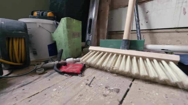 Bathroom renovation; close up tracking shot across stripped back room full of DIY tools during daytime.