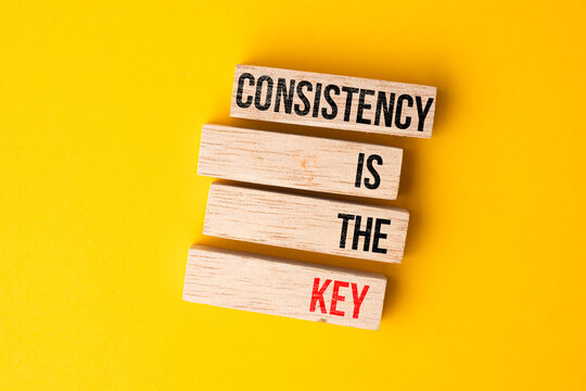 Wooden block with the words CONSISTENCY IS KEY. consistent self-education concept