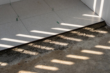 Fototapeta premium Tile installation process in a room interior work bright environment close-up view